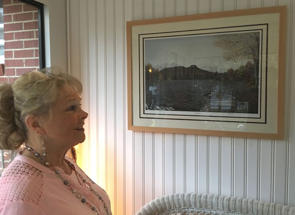 Jane Hall admiring her art print by artist Patricia Hobson "The River."