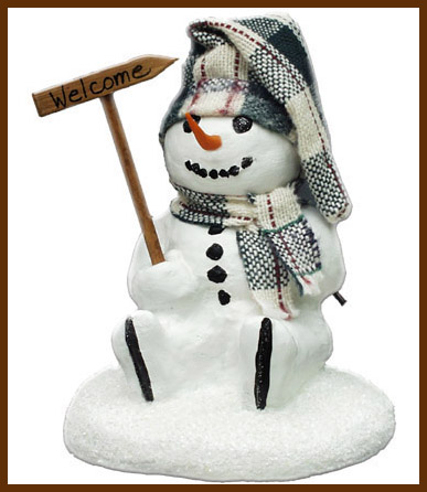 A small sculpture featuring a "Happy" snowman holding a welcome sign.